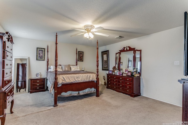 carpeted bedroom featuring ceiling fan and a textured ceiling