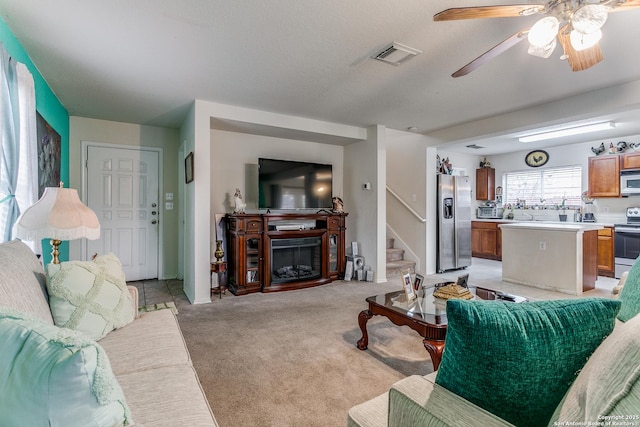 carpeted living room featuring ceiling fan