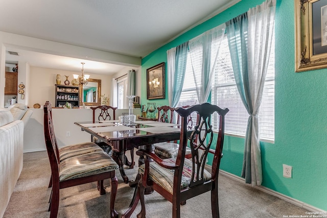 dining space featuring carpet flooring, a notable chandelier, and a healthy amount of sunlight