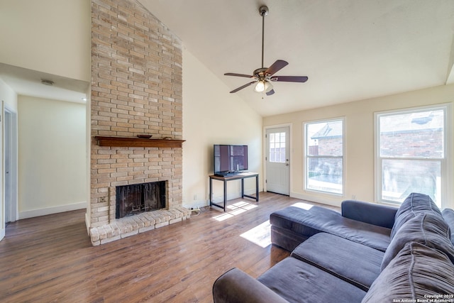 living room featuring a brick fireplace, high vaulted ceiling, dark hardwood / wood-style floors, and a healthy amount of sunlight