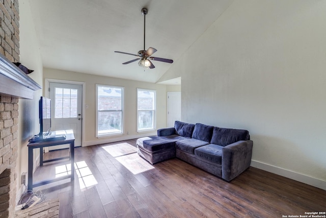 living room featuring dark hardwood / wood-style flooring, a fireplace, lofted ceiling, and ceiling fan