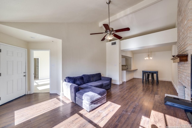 living room with dark hardwood / wood-style flooring, ceiling fan with notable chandelier, a fireplace, and lofted ceiling with beams