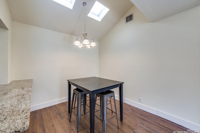 dining area with an inviting chandelier, lofted ceiling with skylight, and dark hardwood / wood-style floors