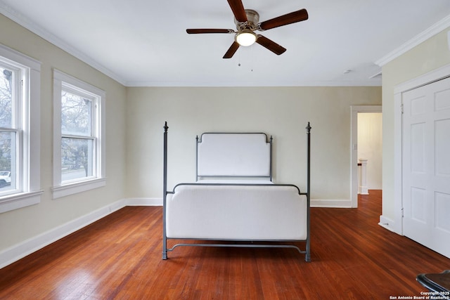 unfurnished bedroom with ceiling fan, dark wood-type flooring, and ornamental molding