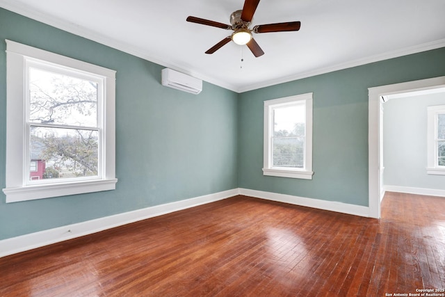 spare room with ceiling fan, an AC wall unit, ornamental molding, and hardwood / wood-style flooring