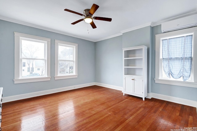 spare room featuring ceiling fan, hardwood / wood-style floors, ornamental molding, and a wall unit AC