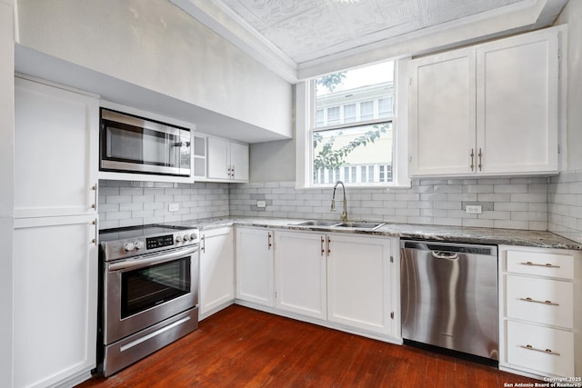 kitchen featuring tasteful backsplash, white cabinets, sink, and stainless steel appliances