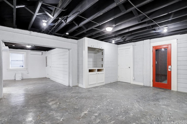 basement featuring wooden walls