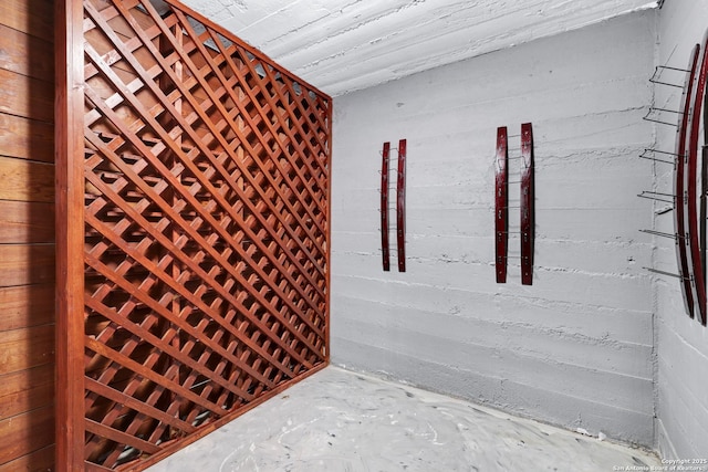 wine area featuring concrete flooring and wooden walls