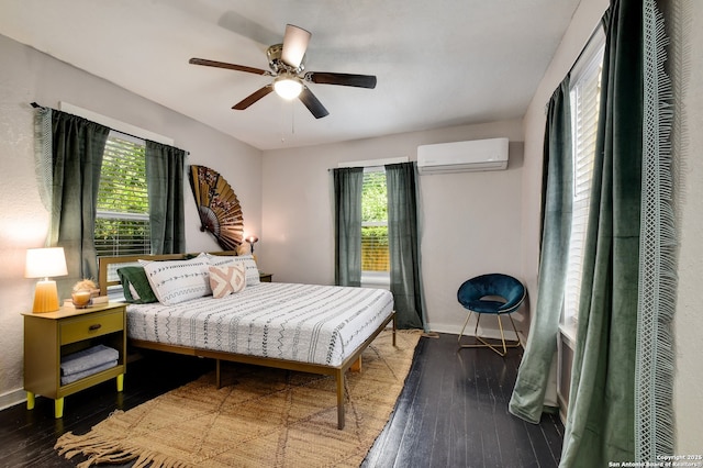 bedroom with ceiling fan, hardwood / wood-style flooring, and a wall unit AC