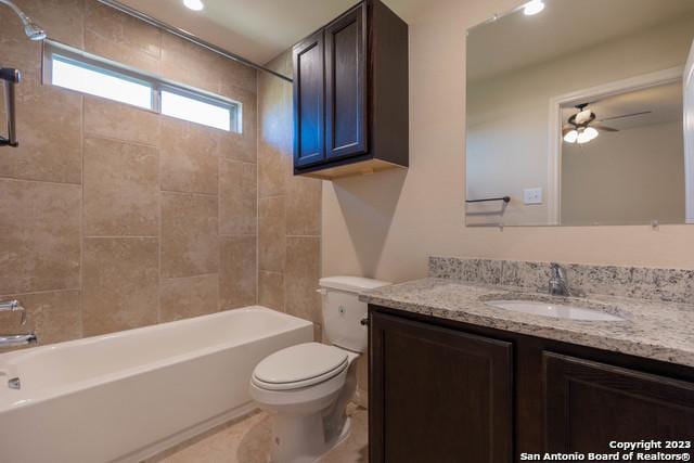 full bathroom with toilet, tiled shower / bath, ceiling fan, and vanity