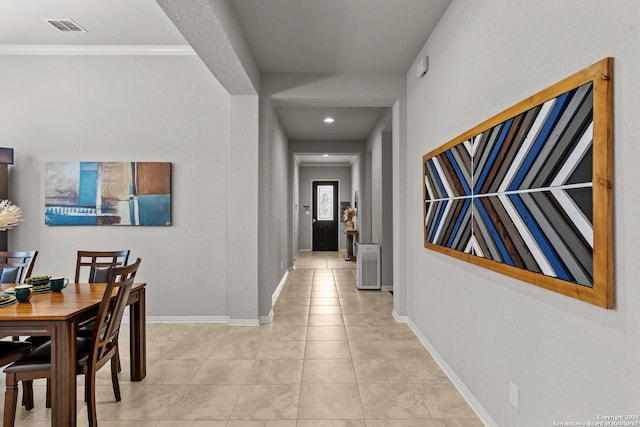 hallway with light tile patterned flooring and crown molding