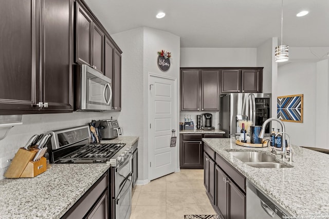 kitchen featuring decorative light fixtures, sink, dark brown cabinetry, appliances with stainless steel finishes, and light tile patterned floors