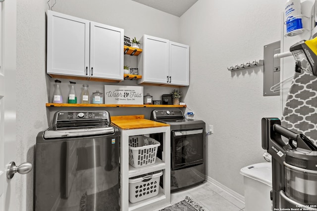 laundry room with cabinets, separate washer and dryer, and light tile patterned floors