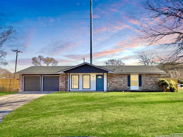 single story home featuring a garage and a yard