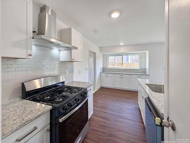 kitchen featuring white cabinets, wall chimney range hood, black dishwasher, and stainless steel range with gas stovetop