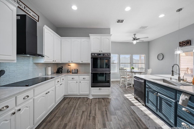 kitchen featuring pendant lighting, black appliances, white cabinetry, wall chimney range hood, and sink