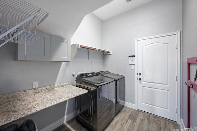 laundry area with separate washer and dryer and light hardwood / wood-style flooring