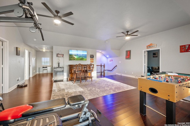 game room with ceiling fan, vaulted ceiling, and dark hardwood / wood-style flooring