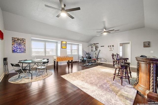 interior space with a textured ceiling, ceiling fan, lofted ceiling, and dark hardwood / wood-style floors