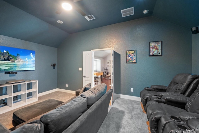 carpeted home theater featuring vaulted ceiling