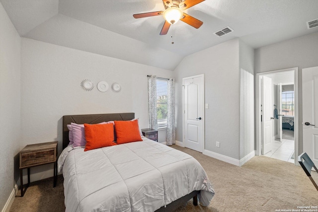 bedroom with ceiling fan, light carpet, and vaulted ceiling