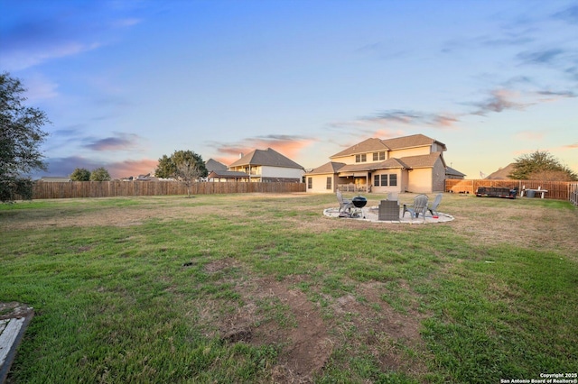 yard at dusk featuring a fire pit and a patio