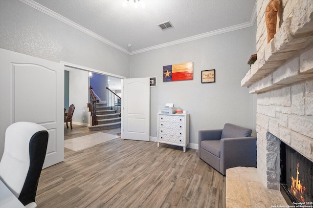 office featuring a textured ceiling, ornamental molding, a fireplace, and wood-type flooring