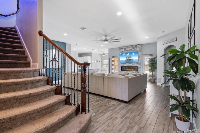 living room featuring ceiling fan and a fireplace