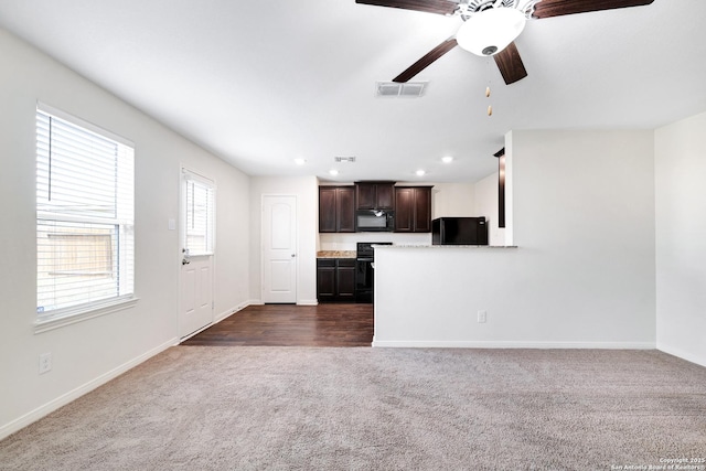 unfurnished living room with dark colored carpet and ceiling fan