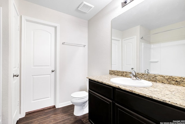 bathroom featuring a shower, wood-type flooring, toilet, and vanity