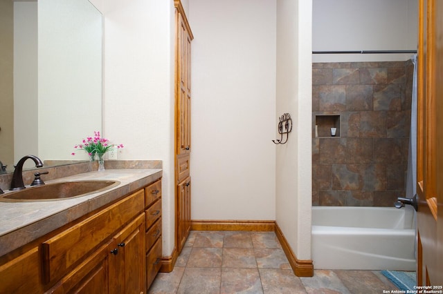 bathroom featuring tiled shower / bath and vanity