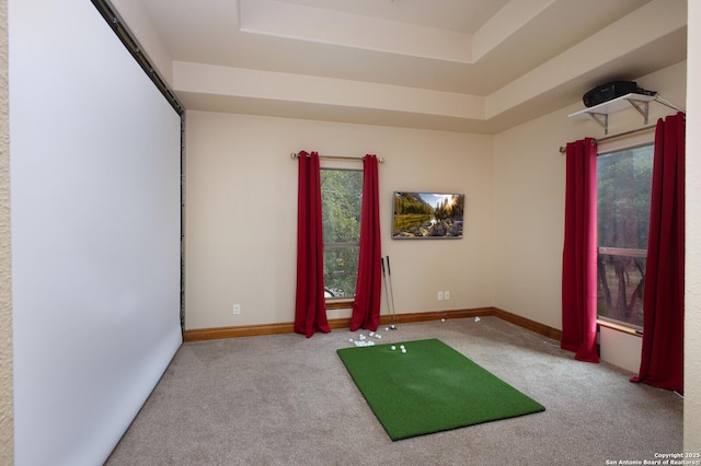 carpeted spare room with a tray ceiling