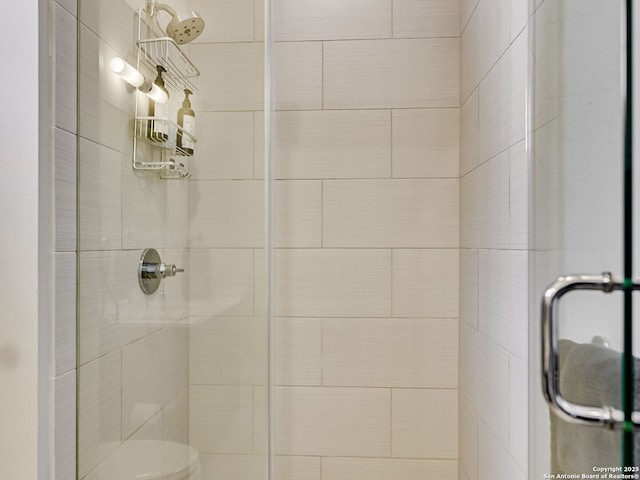 bathroom featuring a shower with shower door and toilet