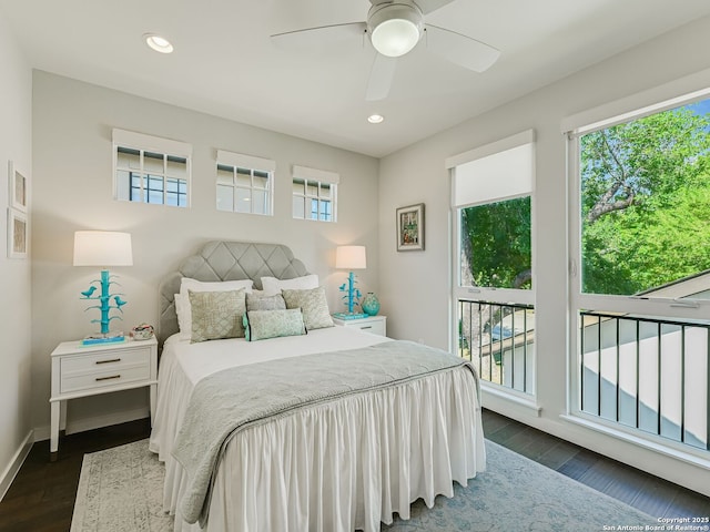 bedroom with ceiling fan, multiple windows, and dark hardwood / wood-style floors