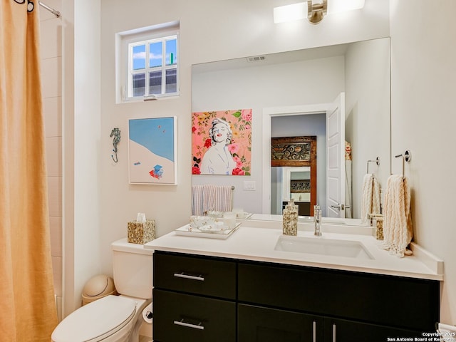 bathroom featuring toilet, a shower with shower curtain, and vanity