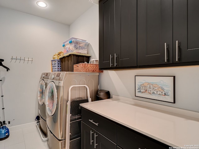 laundry room featuring cabinets, light tile patterned floors, and independent washer and dryer