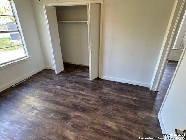 unfurnished bedroom featuring a closet and dark hardwood / wood-style flooring