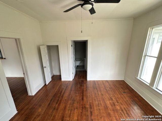 unfurnished bedroom featuring ceiling fan, a spacious closet, and dark hardwood / wood-style flooring