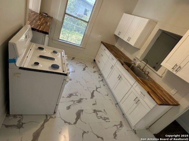 kitchen featuring sink and white cabinetry