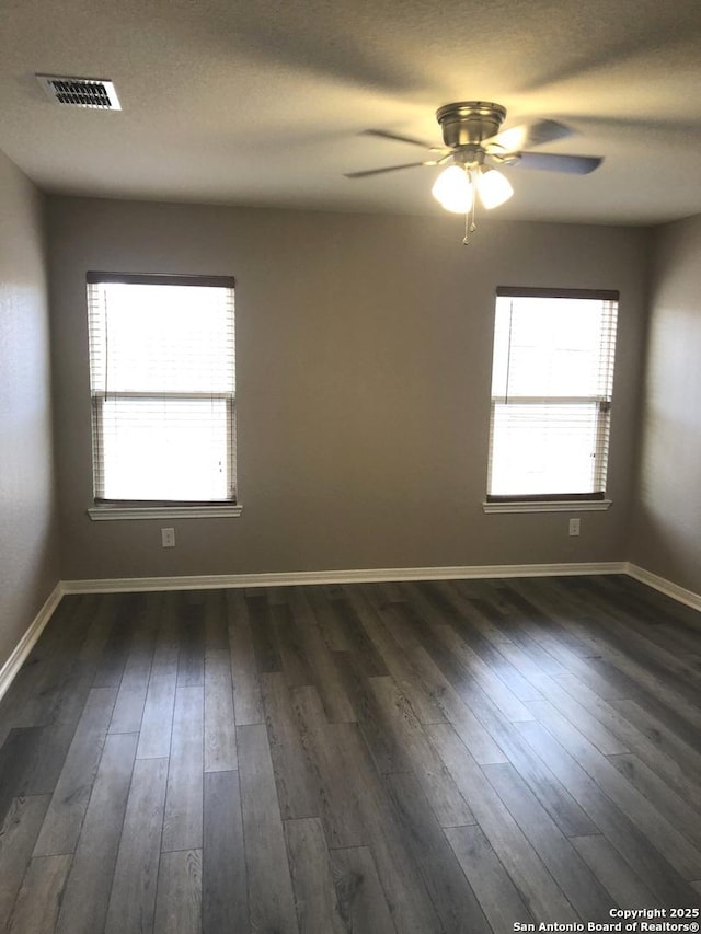 empty room with ceiling fan and dark hardwood / wood-style floors