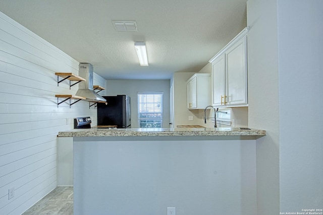 kitchen with white cabinets, kitchen peninsula, extractor fan, and stainless steel appliances