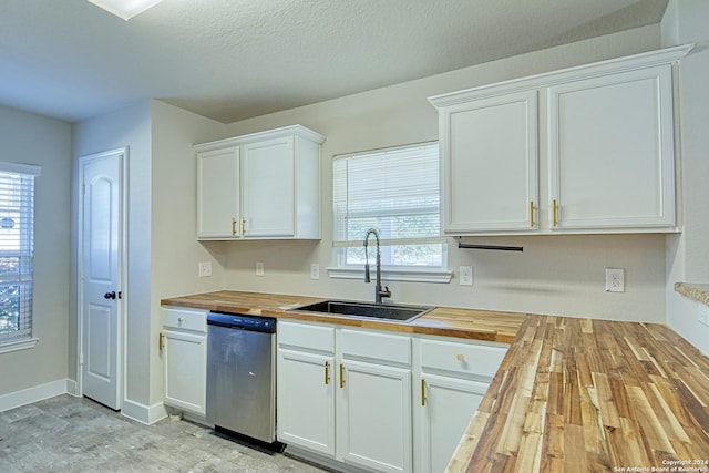 kitchen featuring stainless steel dishwasher, white cabinets, and wooden counters