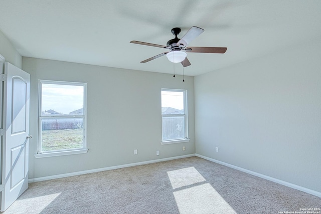 empty room featuring ceiling fan and light colored carpet