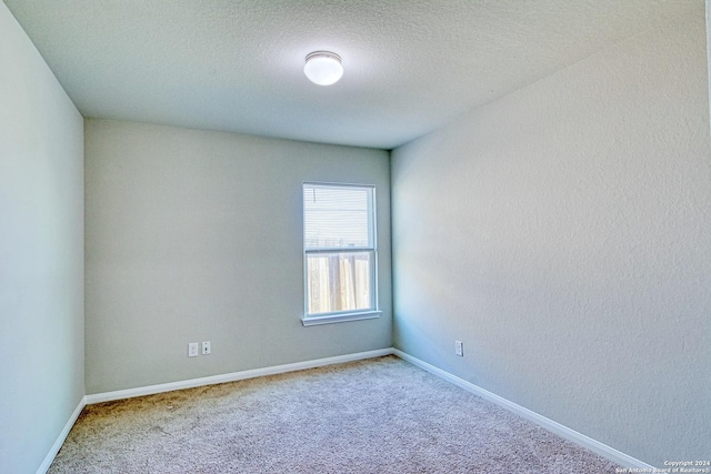 carpeted empty room with a textured ceiling