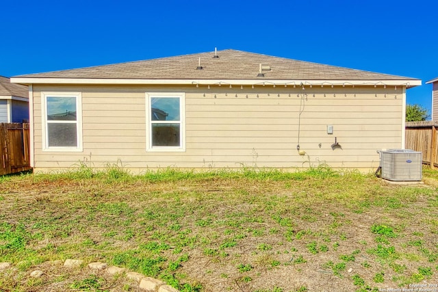 view of side of property featuring central AC unit and a yard