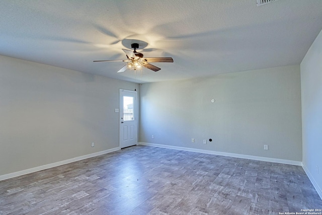 spare room with ceiling fan, a textured ceiling, and hardwood / wood-style flooring