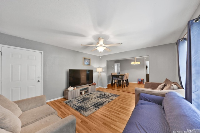 living room featuring ceiling fan and hardwood / wood-style floors