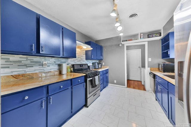 kitchen with decorative backsplash, appliances with stainless steel finishes, and blue cabinets