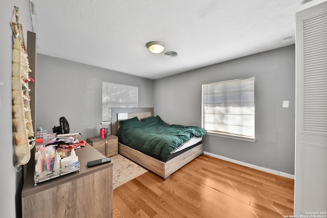 bedroom featuring a textured ceiling and hardwood / wood-style floors